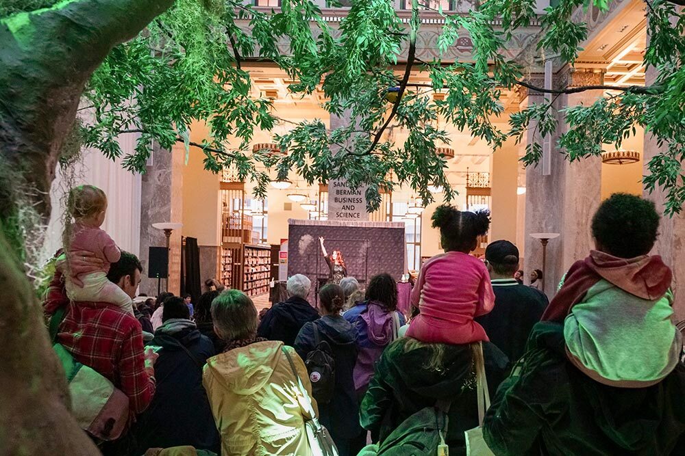 Events at Pratt Library - all ages audience under an indoor tree