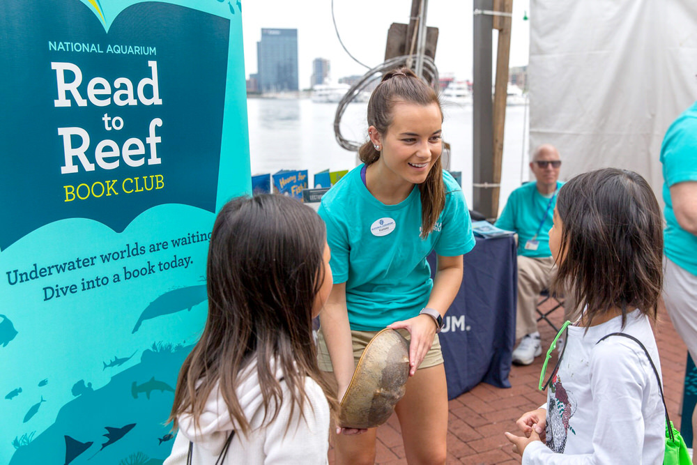 Read to Reef - Aquarium youth education helper showing kids a horseshoe crab