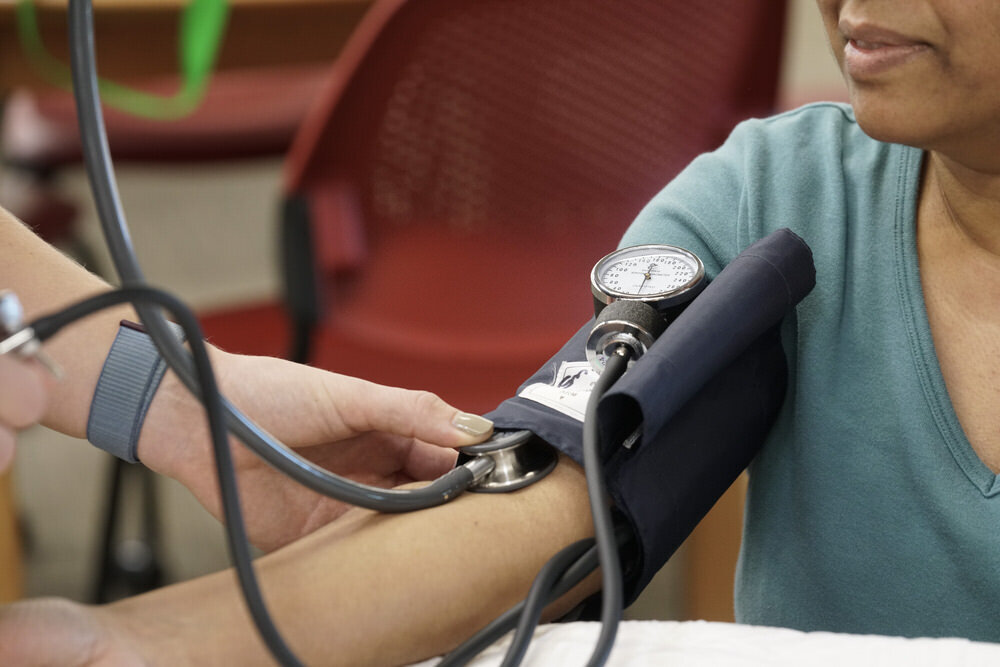 Wellness at Pratt - a woman getting her blood pressure taken by a nurse at the library, closeup