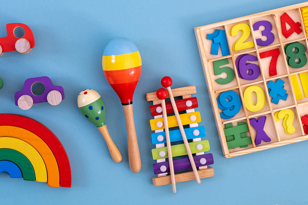 early learning toys for young children, showing a xylophone, shaker, numbers, rainbow colors, and cars