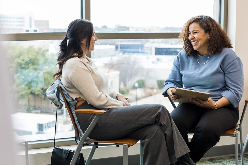 women talking getting advice by a window with a clipboard