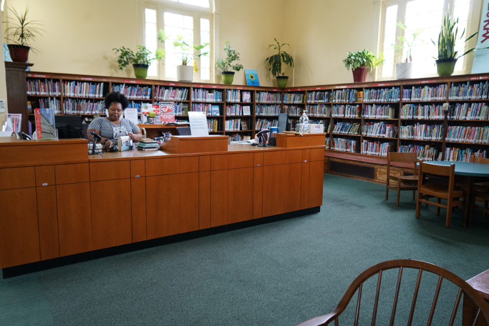 Interior photo of a librarian working at the Govans desk