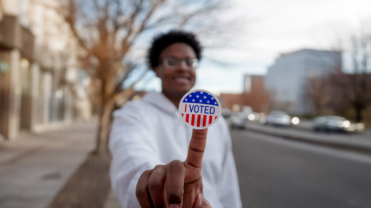 I Voted sticker held by person a outside