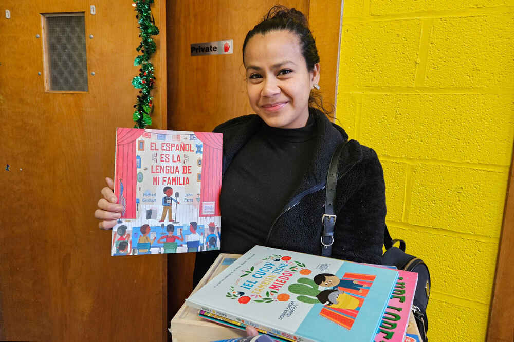 Books for Me - smiling adult holding books in Spanish