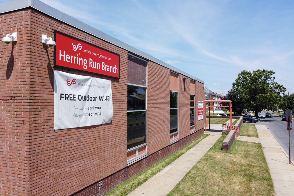Herring Run Branch exterior corner while closed - free Wi-Fi sign