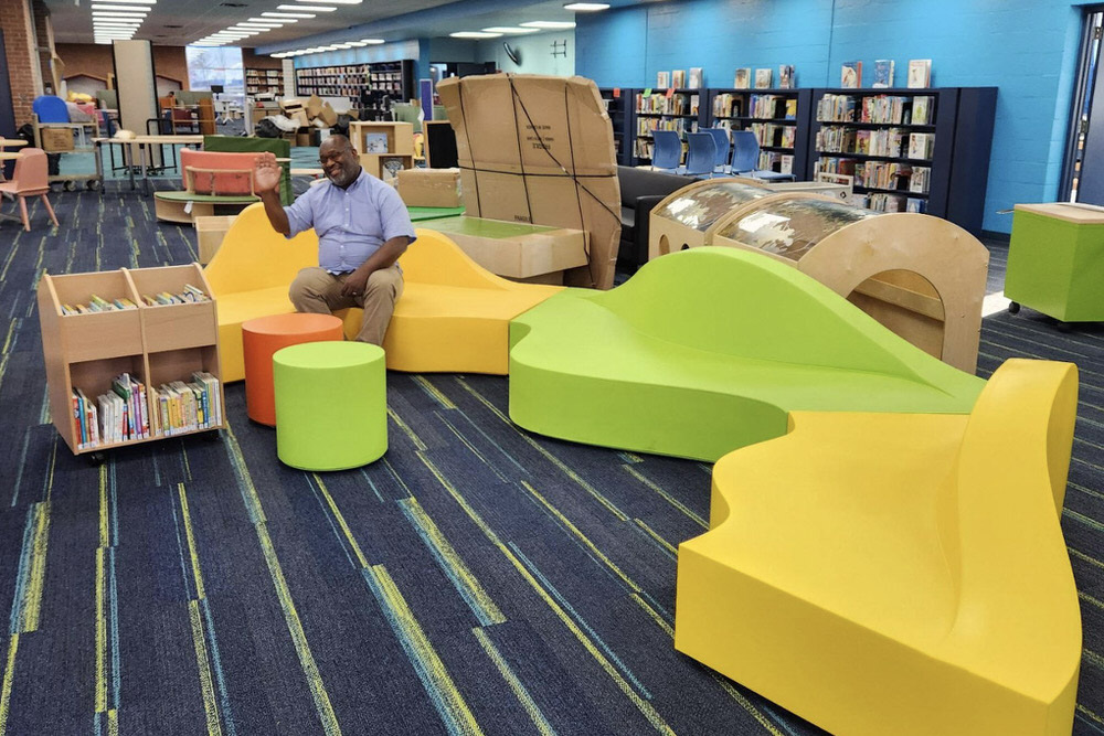 Herring Run branch with colorful new furniture and a person waving