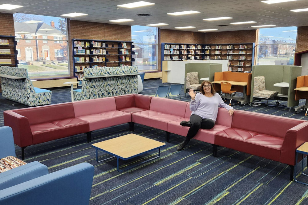 Herring Run branch with new furniture and a person waving