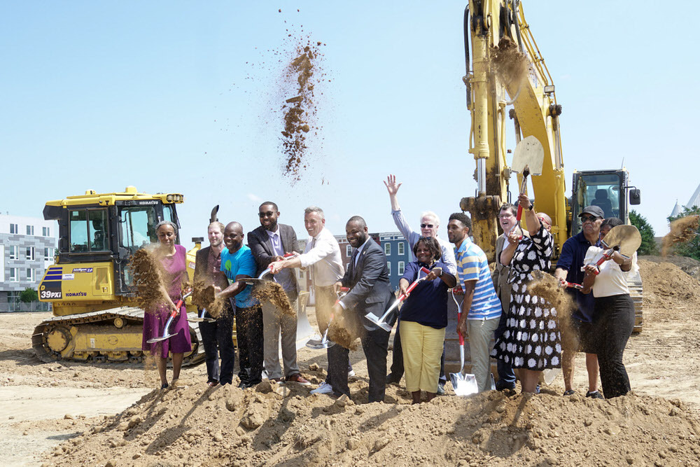 Johnston Square Branch groundbreaking with shovels and dirt in the air