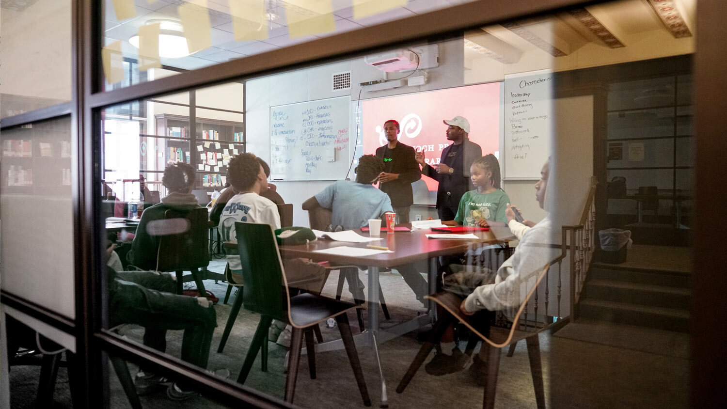 PRATTpreneur meeting room with people, glass walls, ad notes