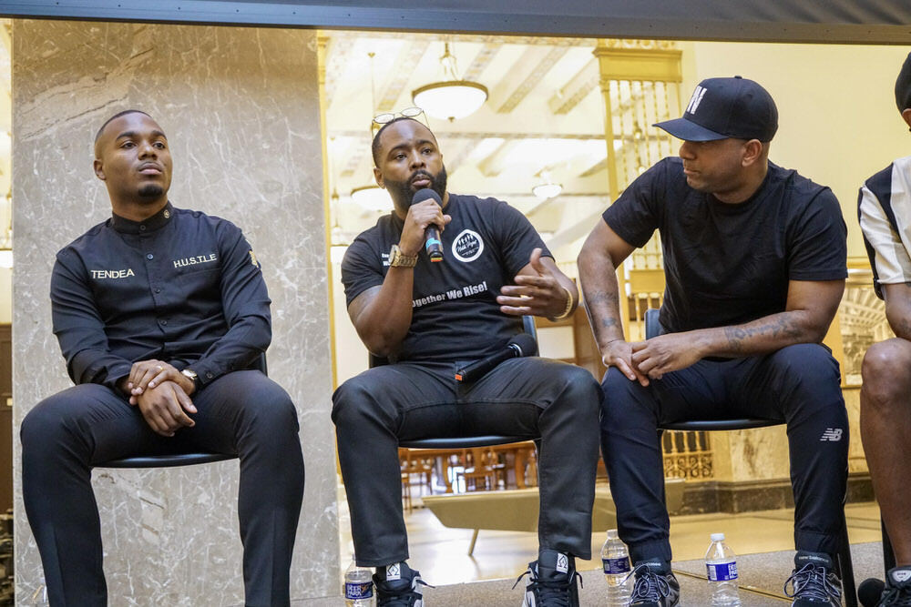 community program with a group of men speaking on stage