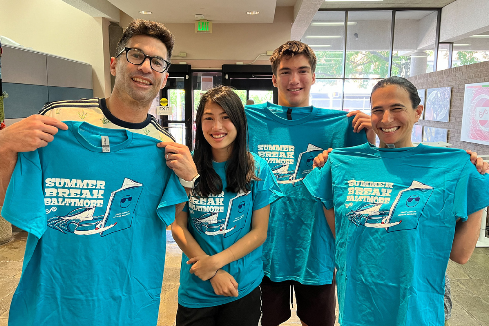 Four adults posing with their blue Summer Break Baltimore 2024 t-shirts