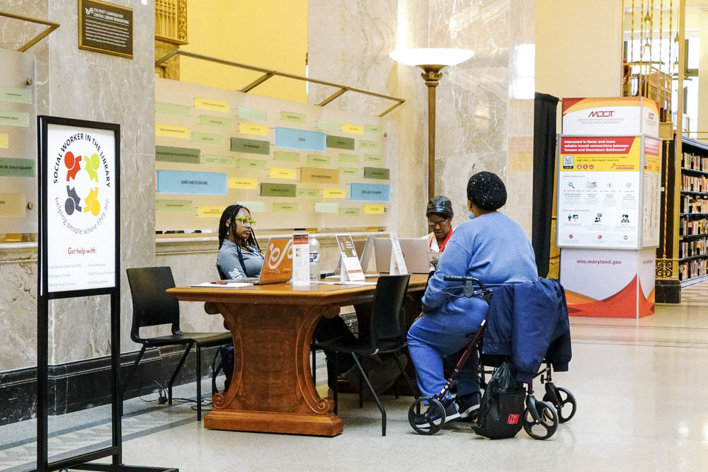 Social worker table, a customer using a wheelchair, library signs