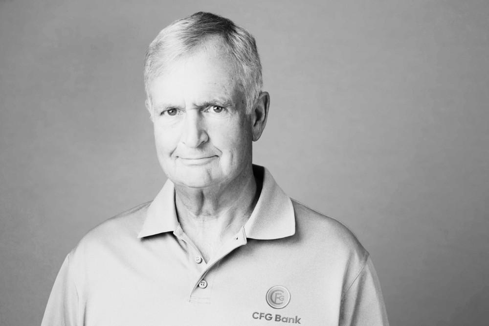 Black and white portrait of Jack Dwyer, a white man looking at the camera. He's wearing a CFG Bank polo shirt.